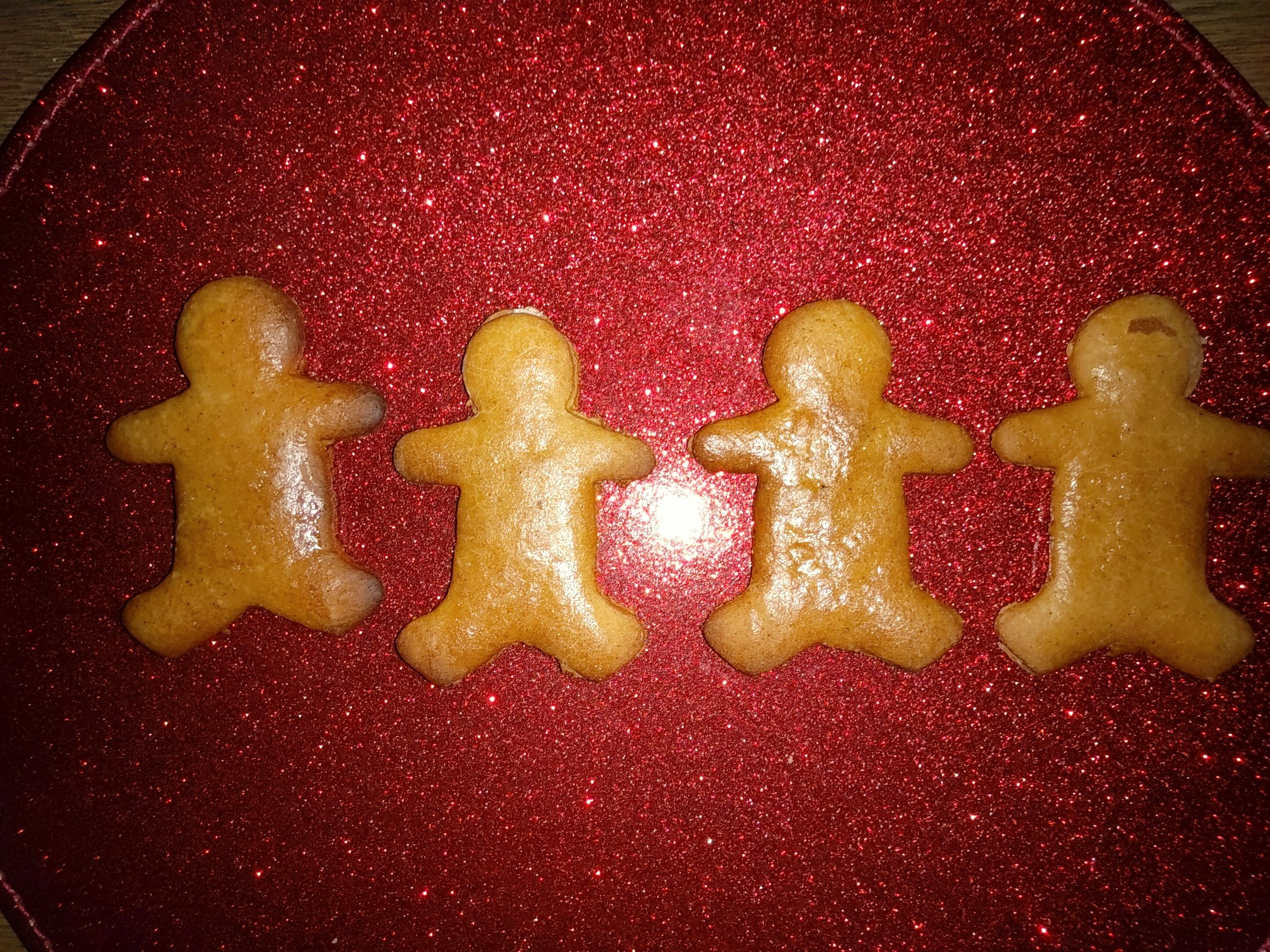 Four glossy honey gingerbread people in a row